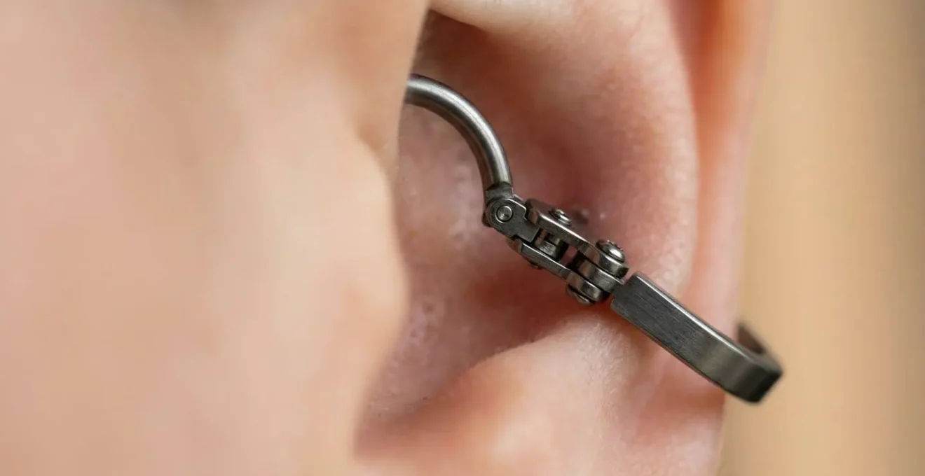 Gros plan sur un anneau clicker en titane posé sur une oreille avec piercing hélix