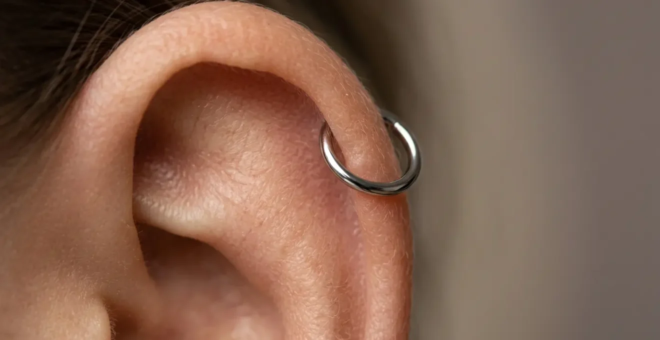 Vue détaillée d'un piercing hélix en titane sur le cartilage supérieur d'une oreille