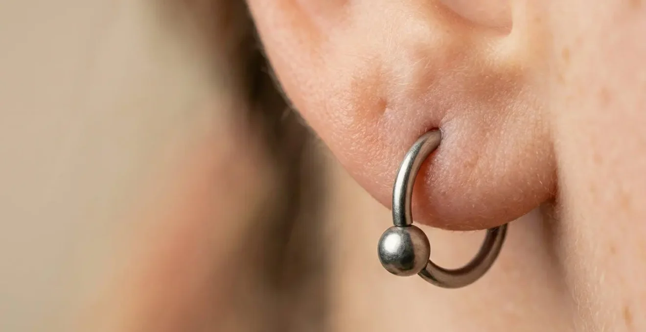 Vue rapprochée d'un lobe d'oreille avec un piercing en titane montrant le diamètre de 1,2 millimètres