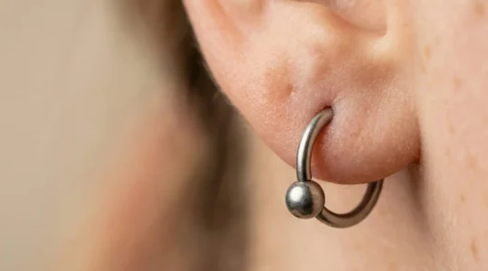 Vue rapprochée d'un lobe d'oreille avec un piercing en titane montrant le diamètre de 1,2 millimètres