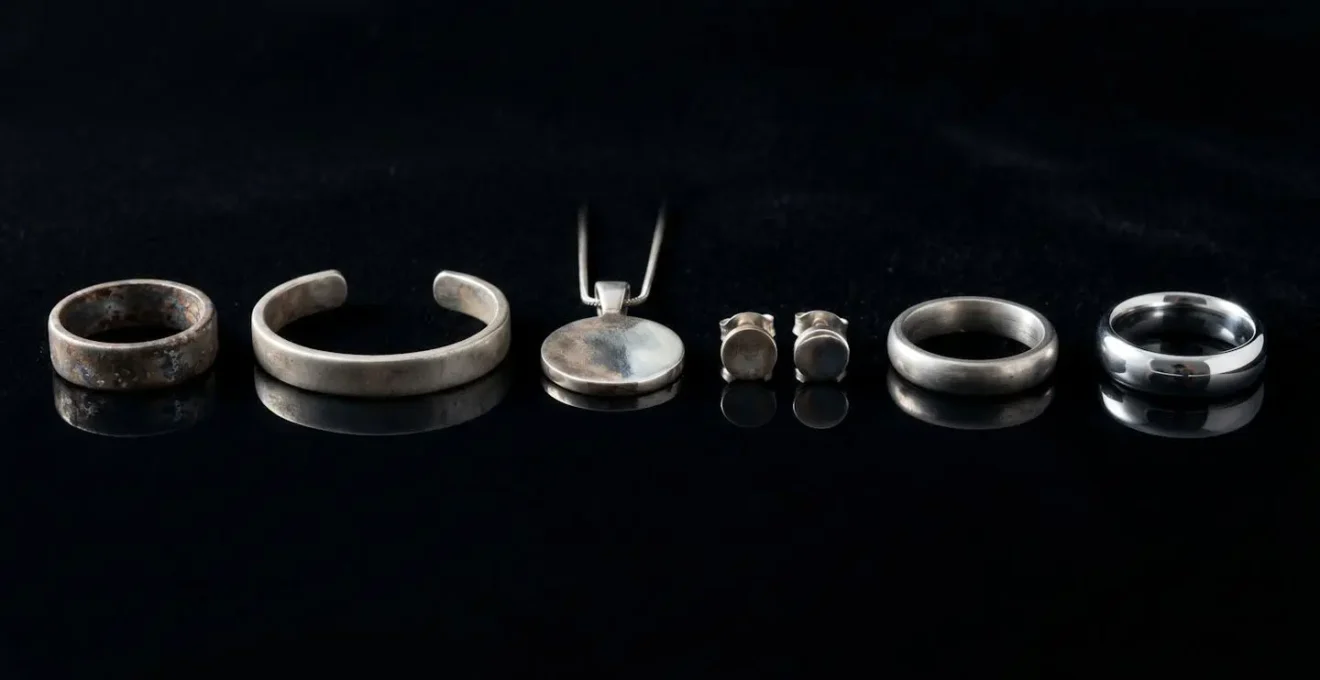 Bijoux de piercing de différentes qualités alignés sur surface réfléchissante